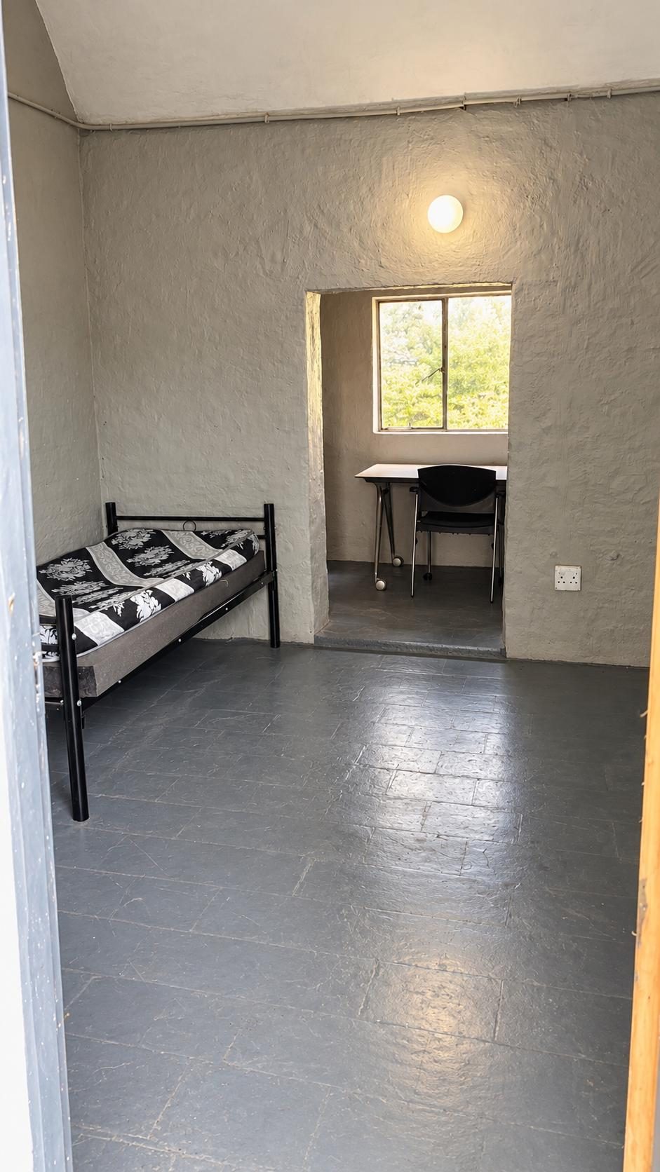 Another view of the shared room, showing one bed and the desk in the window alcove