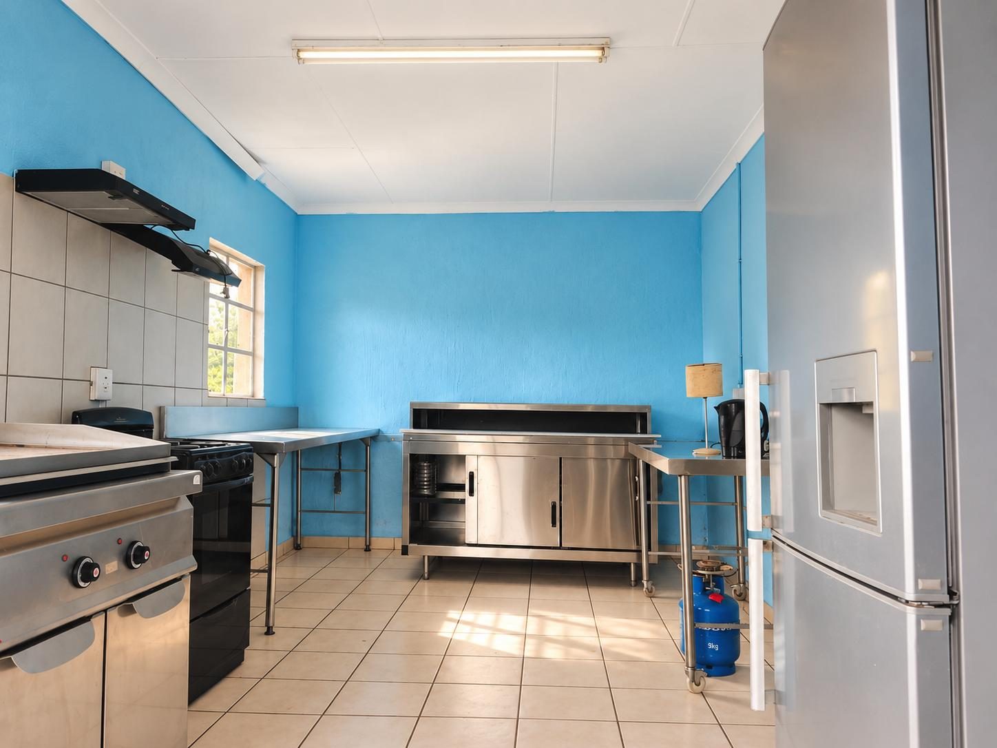 Shared kitchen with a fridge, kettle and stainless-steel counters